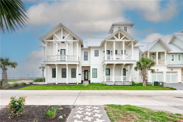 view of front of house with a front yard, a balcony, and a garage