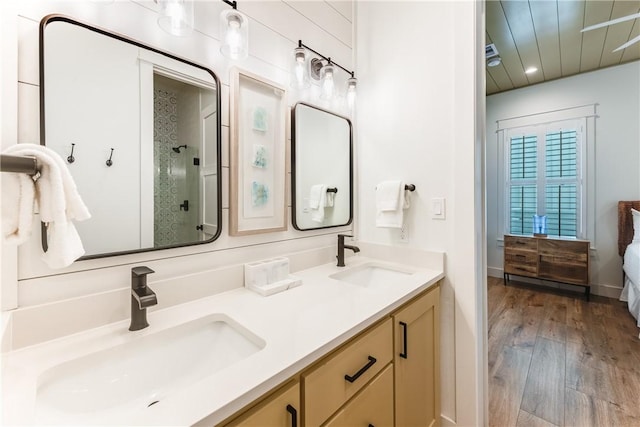 bathroom with wood-type flooring, vanity, and a shower with shower door