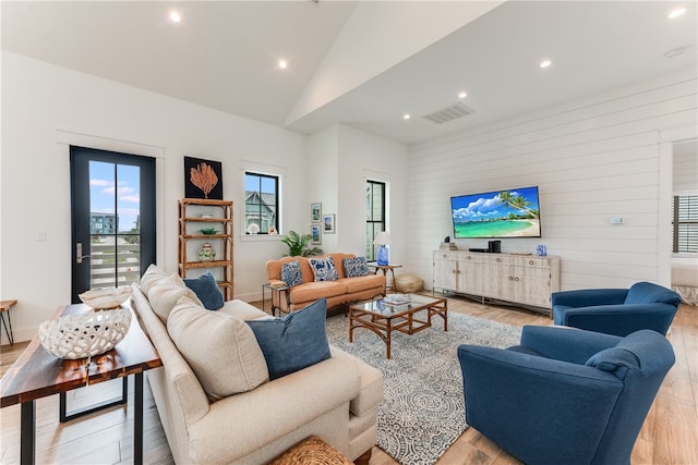 living room with light hardwood / wood-style flooring and lofted ceiling