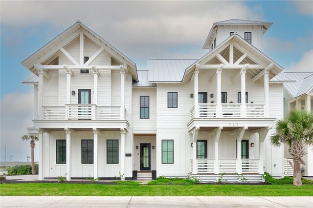 view of front of property featuring a balcony and a front yard