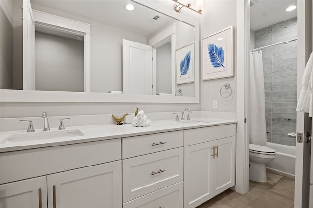 bathroom featuring double vanity, toilet, visible vents, and a sink