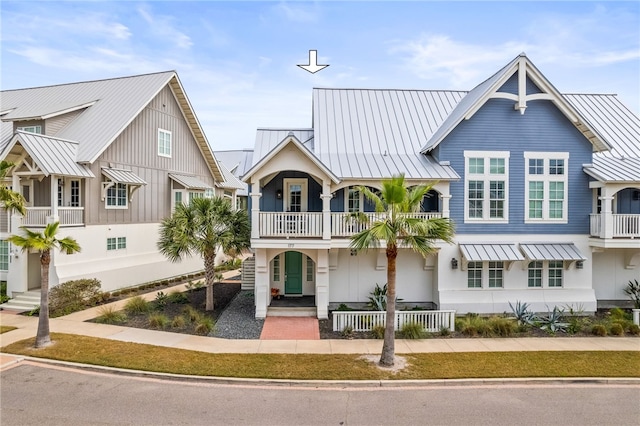 view of front of home featuring metal roof, a balcony, and a standing seam roof