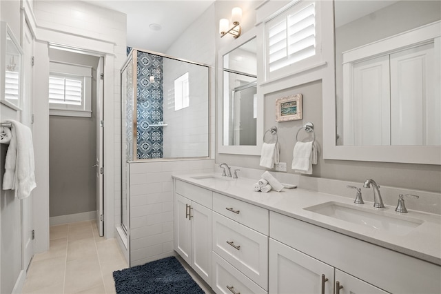 full bath with tile patterned flooring, a shower stall, double vanity, and a sink