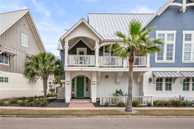 view of front of home with metal roof, a balcony, and a standing seam roof