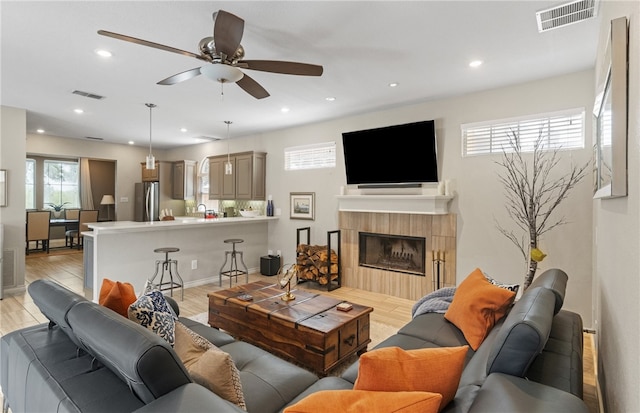 4658 Oso Pkwy, Corpus Christi, TX 78413 - living room featuring a ceiling fan, recessed lighting, a tile fireplace, and light wood-style floors