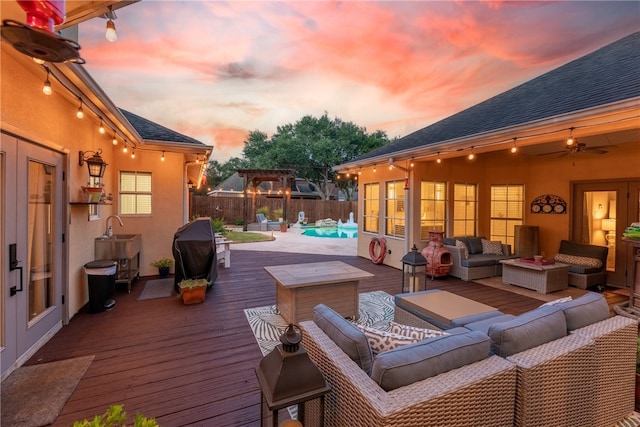 4658 Oso Pkwy, Corpus Christi, TX 78413 - deck at dusk with an outdoor living space, a fenced backyard, and a grill