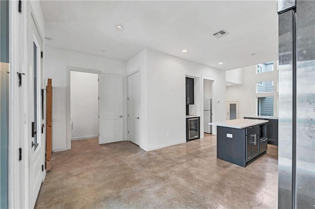 kitchen with a kitchen island, refrigerator, and wine cooler