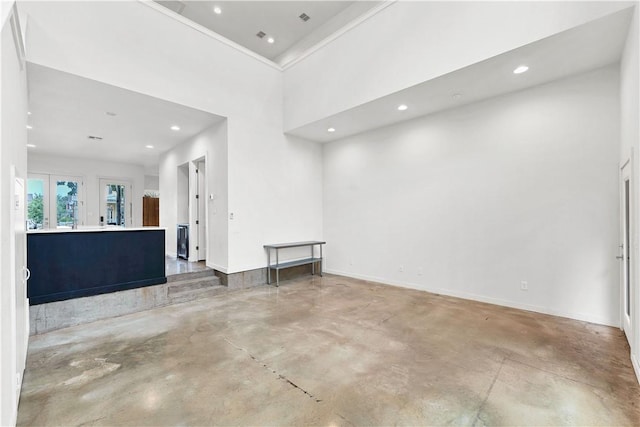 empty room with crown molding and concrete floors