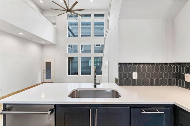 kitchen featuring dishwasher, sink, ceiling fan, and a high ceiling