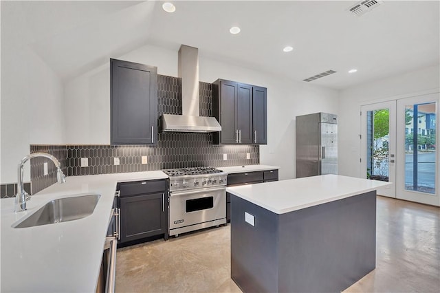 kitchen featuring sink, wall chimney exhaust hood, french doors, a kitchen island, and appliances with stainless steel finishes