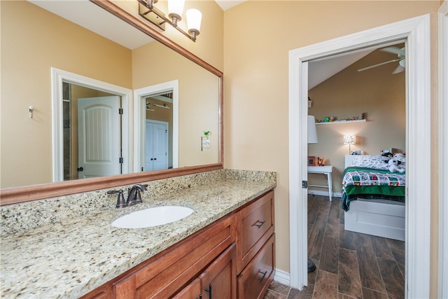 bathroom featuring ceiling fan, hardwood / wood-style floors, vanity, and lofted ceiling