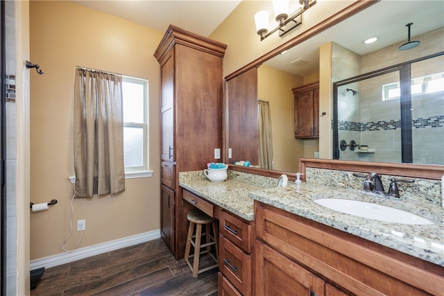 bathroom featuring wood-type flooring, vanity, and a shower with shower door