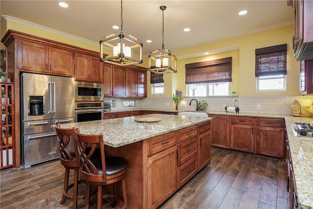 kitchen with a center island, backsplash, crown molding, dark hardwood / wood-style floors, and appliances with stainless steel finishes