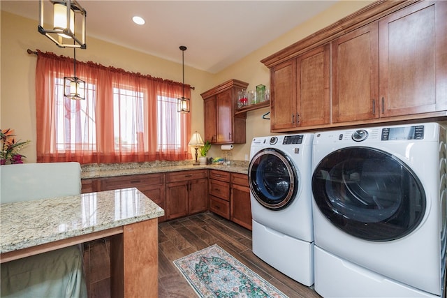 laundry area featuring washer and dryer, dark wood-type flooring, and cabinets