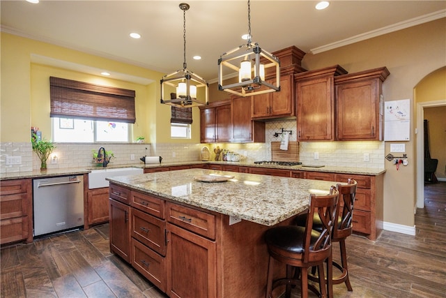 kitchen featuring crown molding, sink, dark hardwood / wood-style floors, a kitchen island, and stainless steel appliances