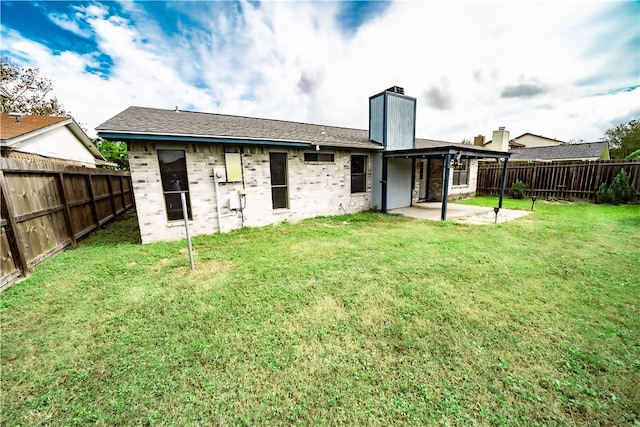 back of property with a lawn and a patio