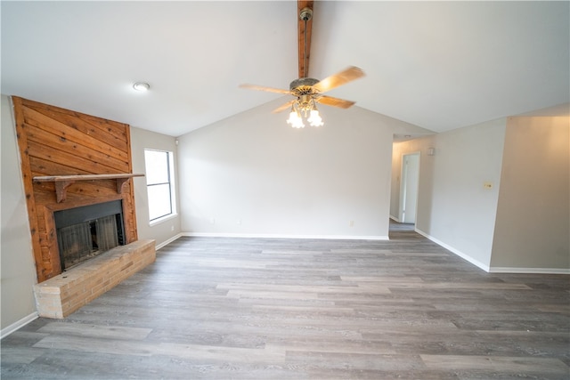 unfurnished living room with a brick fireplace, wood-type flooring, ceiling fan, and vaulted ceiling