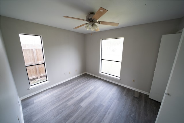 unfurnished room with ceiling fan, dark hardwood / wood-style floors, and plenty of natural light