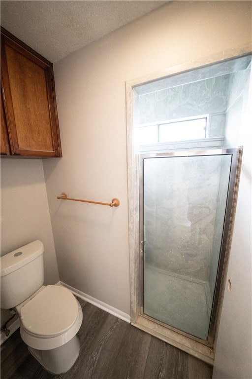 bathroom with hardwood / wood-style floors, a textured ceiling, and toilet