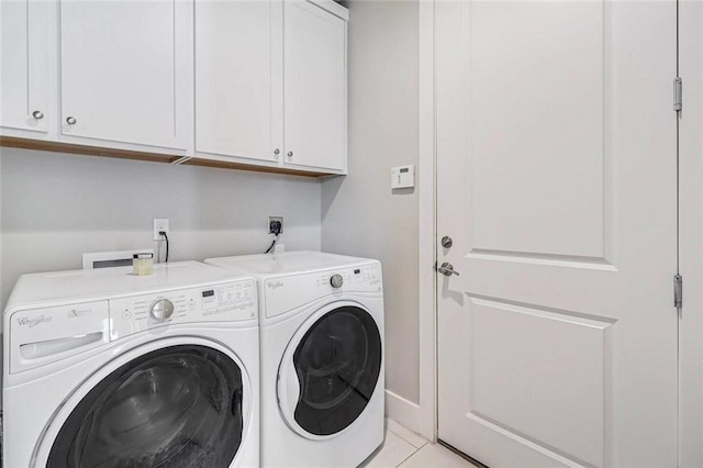 clothes washing area with cabinets and independent washer and dryer