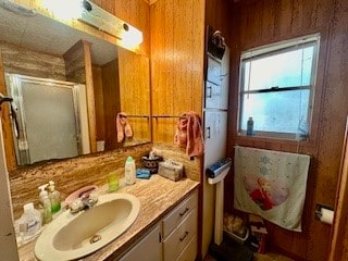 bathroom featuring wood walls, vanity, and a shower with door