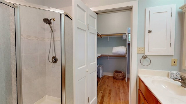 bathroom featuring vanity, a shower with shower door, and hardwood / wood-style floors