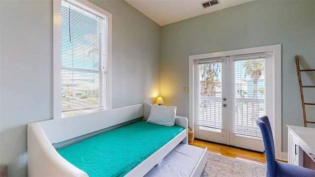 bedroom with access to outside, light hardwood / wood-style floors, and french doors