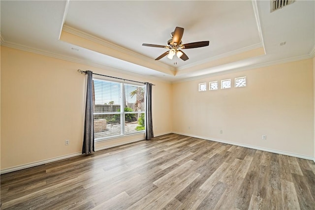 14825 Dasmarinas Dr, Corpus Christi, TX 78418 - empty room featuring a raised ceiling, plenty of natural light, a ceiling fan, wood finished floors, and crown molding