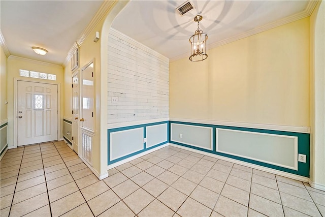 14825 Dasmarinas Dr, Corpus Christi, TX 78418 - foyer with light tile patterned flooring, crown molding, a chandelier, a decorative wall, and a wainscoted wall