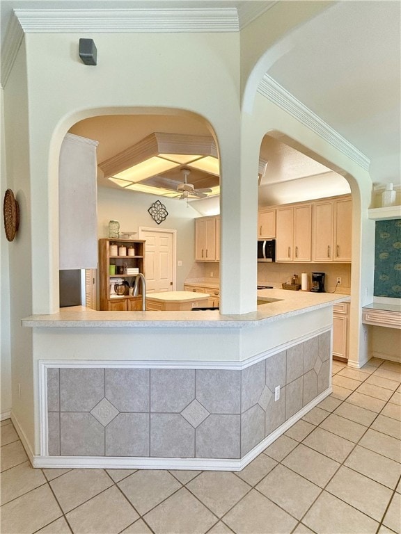 kitchen with light brown cabinets, light tile patterned floors, ceiling fan, and ornamental molding