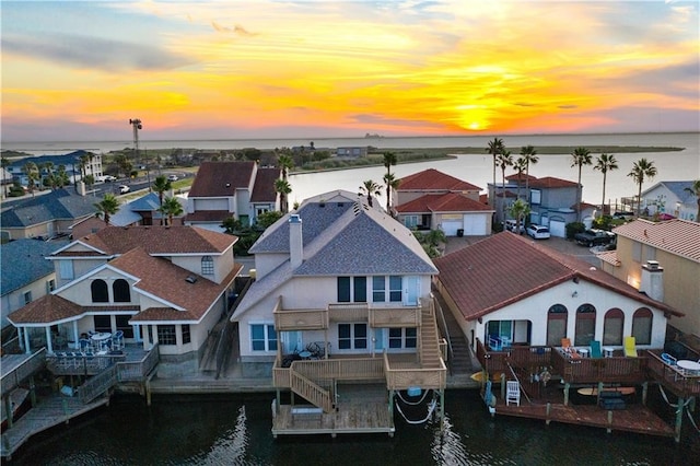 aerial view at dusk featuring a water view