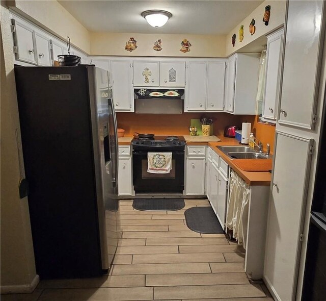 9334 Moon Beam, Corpus Christi, TX 78409 - kitchen with black stove, stainless steel refrigerator with ice dispenser, a sink, range hood, and white cabinetry