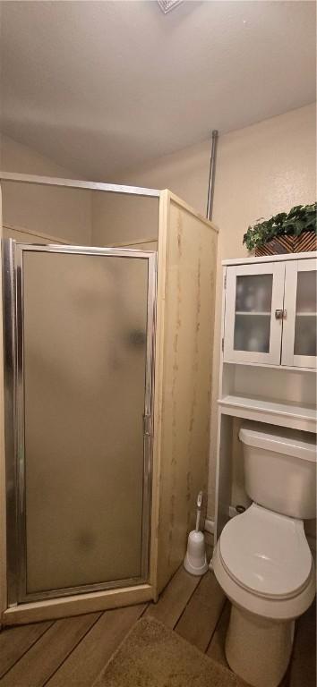 9334 Moon Beam, Corpus Christi, TX 78409 - full bath with a stall shower, toilet, and wood finished floors
