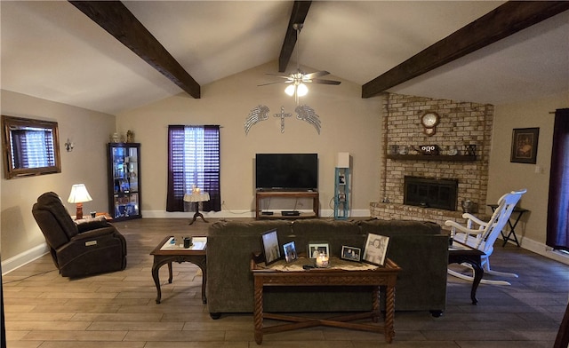 living room with ceiling fan, a fireplace, lofted ceiling with beams, and hardwood / wood-style flooring