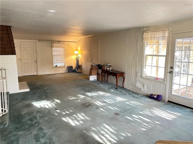 interior space with plenty of natural light and dark carpet