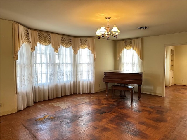 miscellaneous room featuring dark parquet flooring, a wealth of natural light, and a notable chandelier