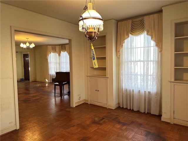 unfurnished dining area featuring dark parquet flooring, an inviting chandelier, and plenty of natural light