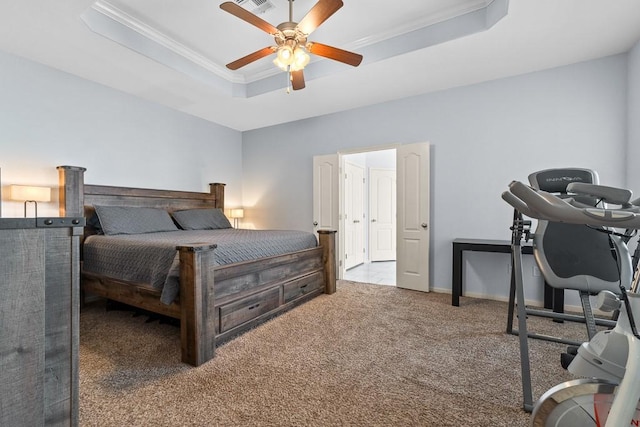 bedroom with ornamental molding, carpet flooring, baseboards, a tray ceiling, and a ceiling fan