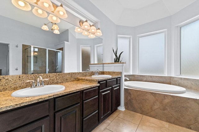 bathroom featuring a garden tub, a sink, a stall shower, and double vanity