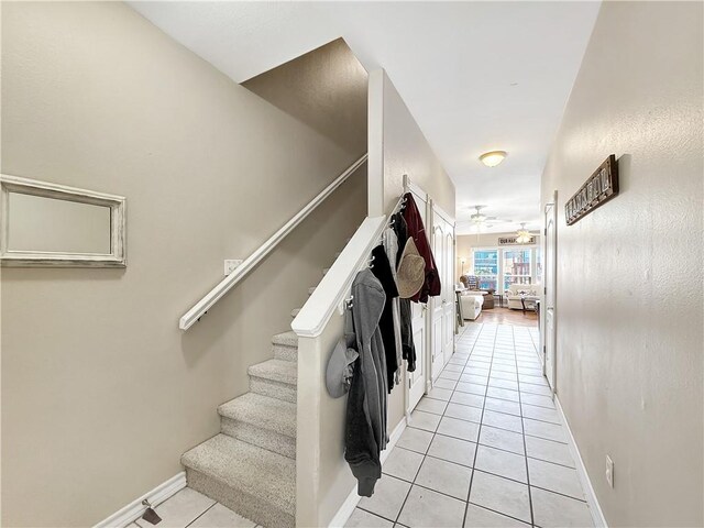 hallway with light tile patterned floors and baseboards