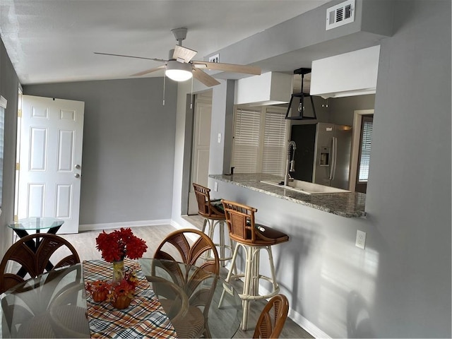 3321 Houston St, Corpus Christi, TX 78411 - kitchen featuring stainless steel fridge, vaulted ceiling, baseboards, ceiling fan, and a sink