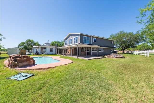 rear view of property with an outdoor fire pit, a patio, and a yard