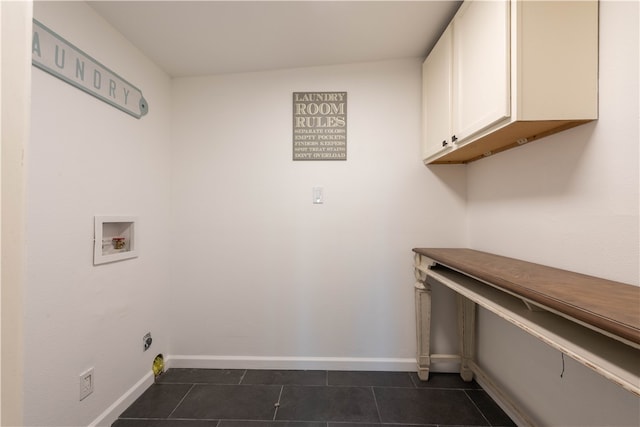 washroom featuring cabinets, washer hookup, and dark tile patterned flooring