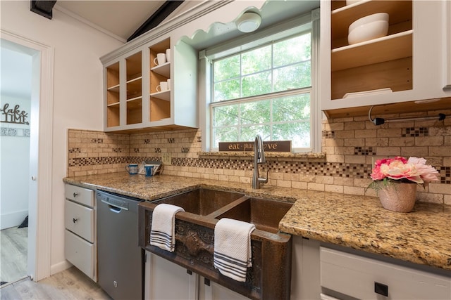 kitchen with white cabinetry, light stone counters, tasteful backsplash, stainless steel dishwasher, and light wood-type flooring