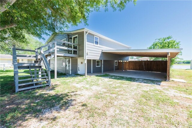 132 Zenna Dr, Mathis, TX 78368 - back of house featuring a carport, stairway, and fence