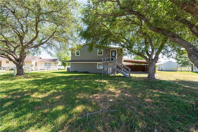 back of house with a storage unit and a lawn