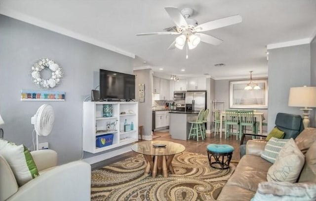 living room with crown molding and ceiling fan with notable chandelier