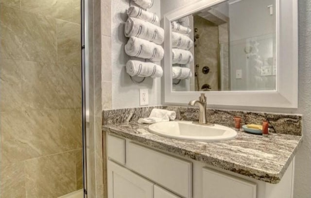 bathroom with a shower with door and vanity