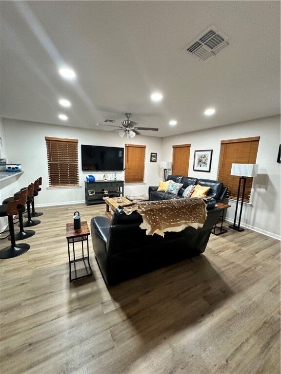 living room featuring light hardwood / wood-style flooring and ceiling fan