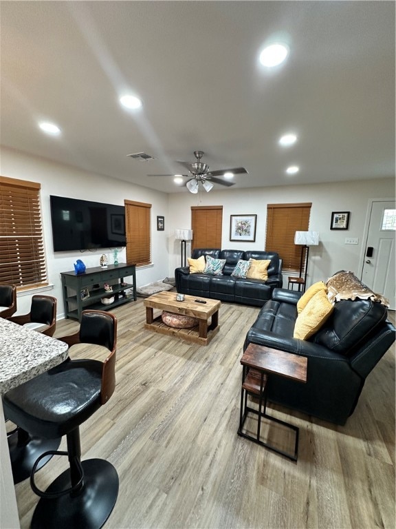 living room featuring light wood-type flooring and ceiling fan